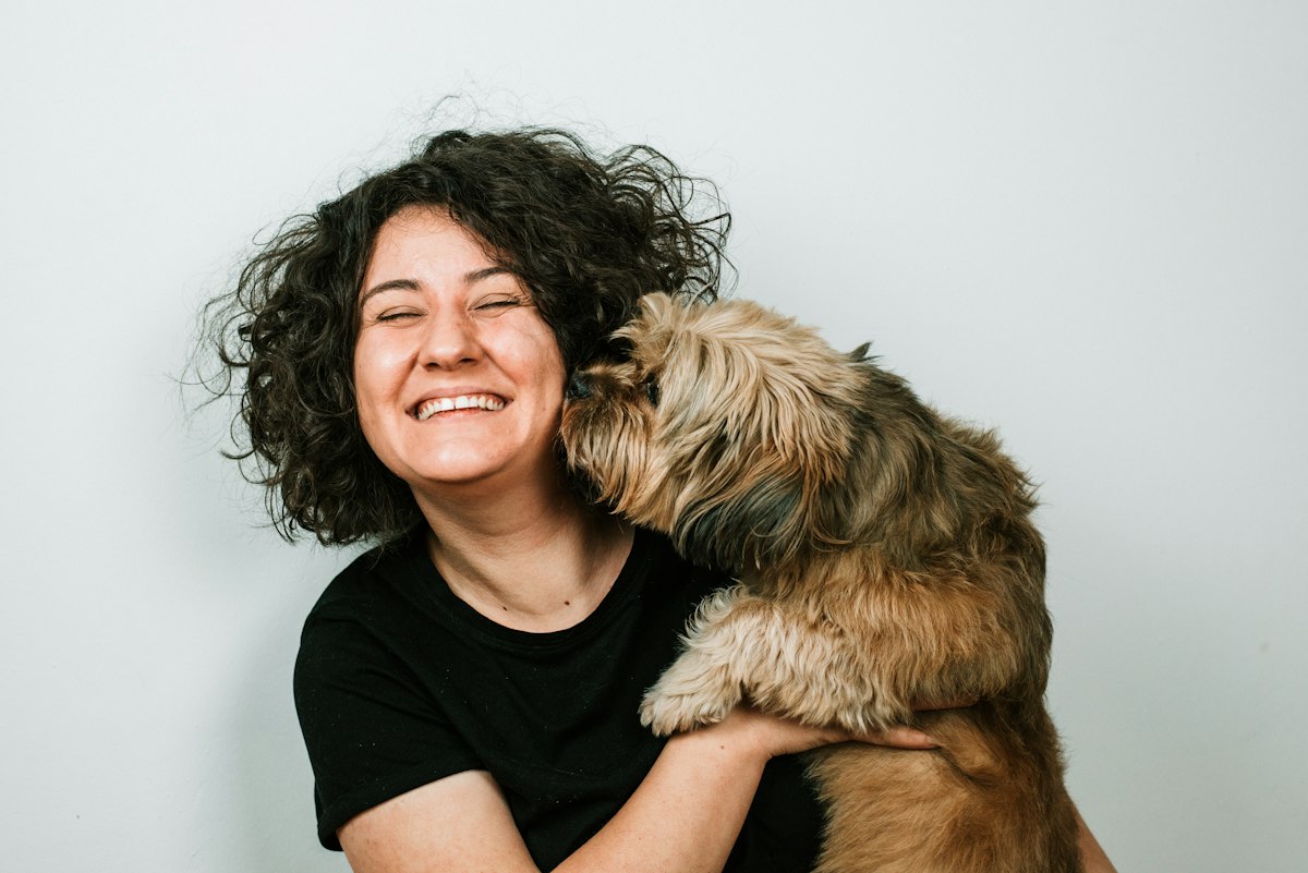 Stand-in photo: a groomer with a freshly groomed dog